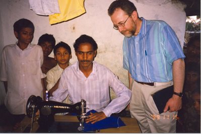 Peter Derrick with students learning how to sew